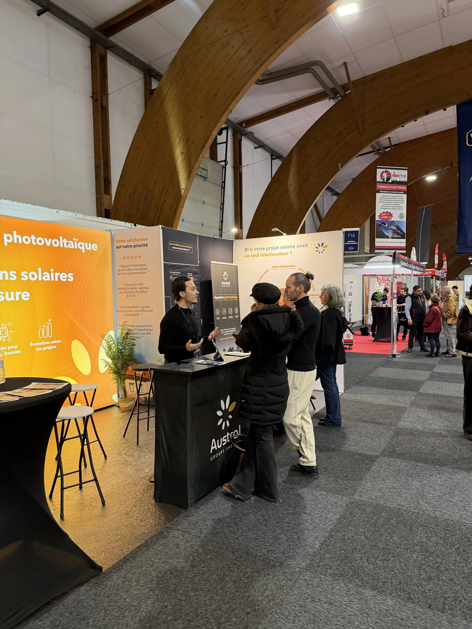 Stand Austral Groupe Énergie « Expert en photovoltaïque » au salon Viving — échanges au comptoir d'accueil côté allée