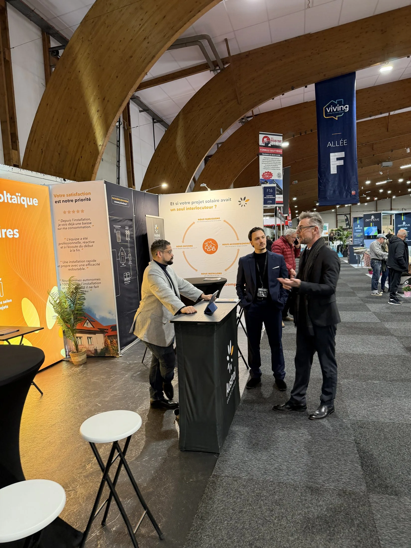 Stand Austral Groupe Énergie « Expert en photovoltaïque » au salon Viving — accueil d'un visiteur dans l'allée F